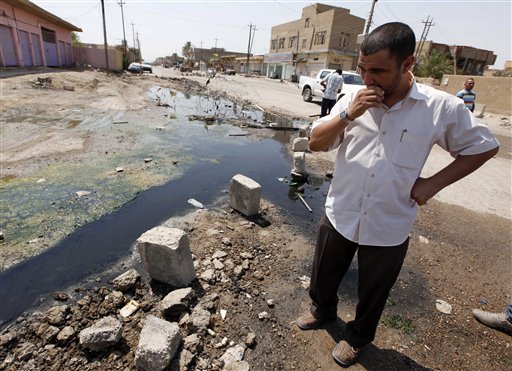 In this Sunday, Aug. 15, 2010 photo, a man stands in a sewage-filled street in Fallujah, Iraq, 40 miles (65 kilometers) west of Baghdad. The Fallujah waste water treatment system is almost finished _ at a cost of more than three times the original estimate and four years past the initial deadline. The sewage facility is among hundreds of projects funded by U.S. taxpayers that remain abandoned or incomplete, wasting more than $5 billion, according to auditors. (AP Photo/Hadi Mizban) (AP)