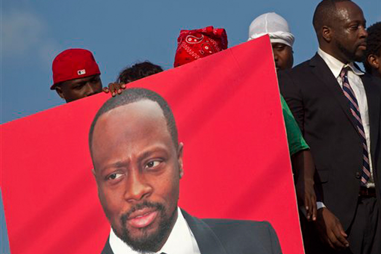 Wyclef Jean, right, leaves the electoral office in Port-au-Prince after submitting paperwork to run for president of Haiti.
