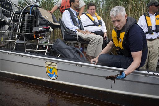 FILE - In this May 26, 2010 publicity image released by CNN, CNN's Anderson Cooper, right, inspects the oil spill during a tour with Louisiana Gov. Bobby Jindal, background left, of the contaminated areas in Blind Bay, La. (AP Photo/CNN, Shaul Schwarz) (AP)