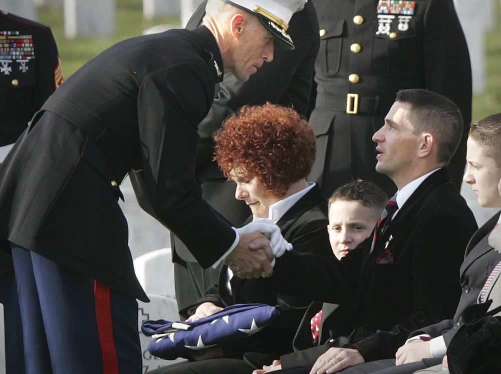 Marine Col. Gregory Boyle, left, pays his respects to the parents of Pvt. Heath D. Warner, of Canton, Ohio, Melissa and Scott Warner, after handing them the U.S. flag that was draped his casket, during funeral service at Arlington National Cemetery, in Arlington, Va., Tuesday, Dec. 12, 2006.