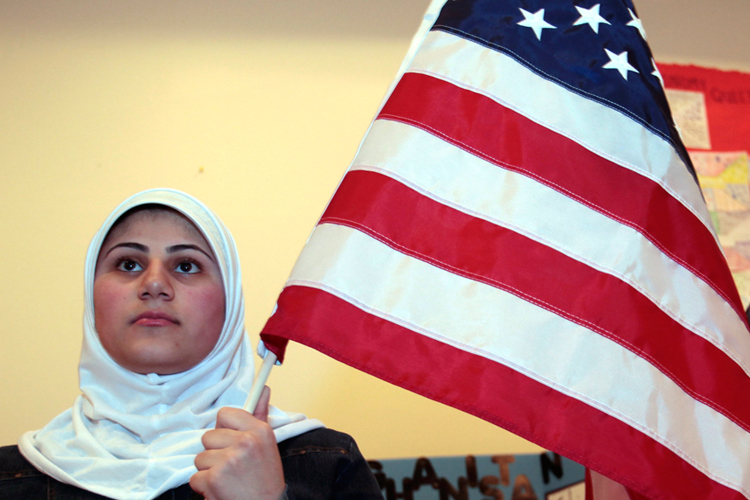 A young Muslim American woman holds the U.S. flag at the Islamic Center of America in Dearborn, Michigan on March 26.