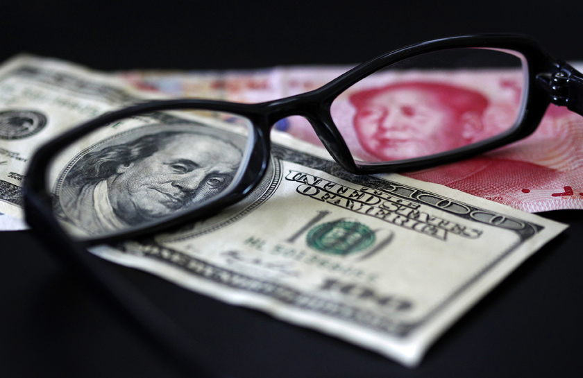 A U.S. dollar note (L) and a Chinese yuan banknote are seen through a pair of spectacles in this picture illustration taken in Taipei October 13, 2010. China's foreign exchange reserves soared in the third quarter and its trade surplus remained hefty, showing that the country is under both economic and political pressure to let the yuan rise more quickly.  REUTERS/Nicky Loh (TAIWAN - Tags: BUSINESS) (Â© Nicky Loh / Reuters)