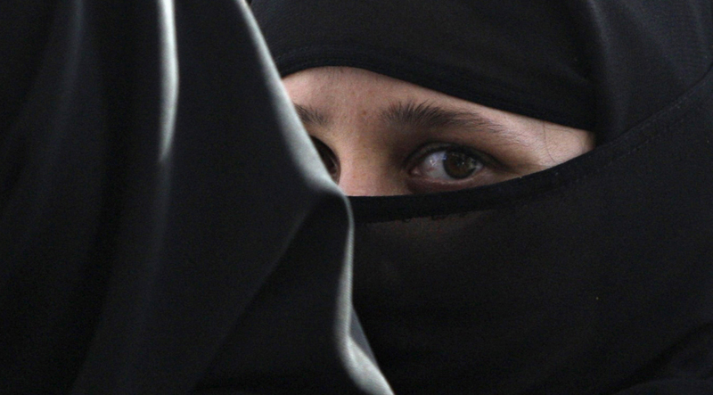 A girl wearing a burqa hides behind another as they visit the Abdullah Shah Ghazi Mausoleum in Karachi April 23, 2009. Hundreds of devotees pay their respects daily at the tomb of Ghazi, a ninth-century Sufi saint.  REUTERS/Athar Hussain   (PAKISTAN RELIGION) (Â© Athar Hussain / Reuters)
