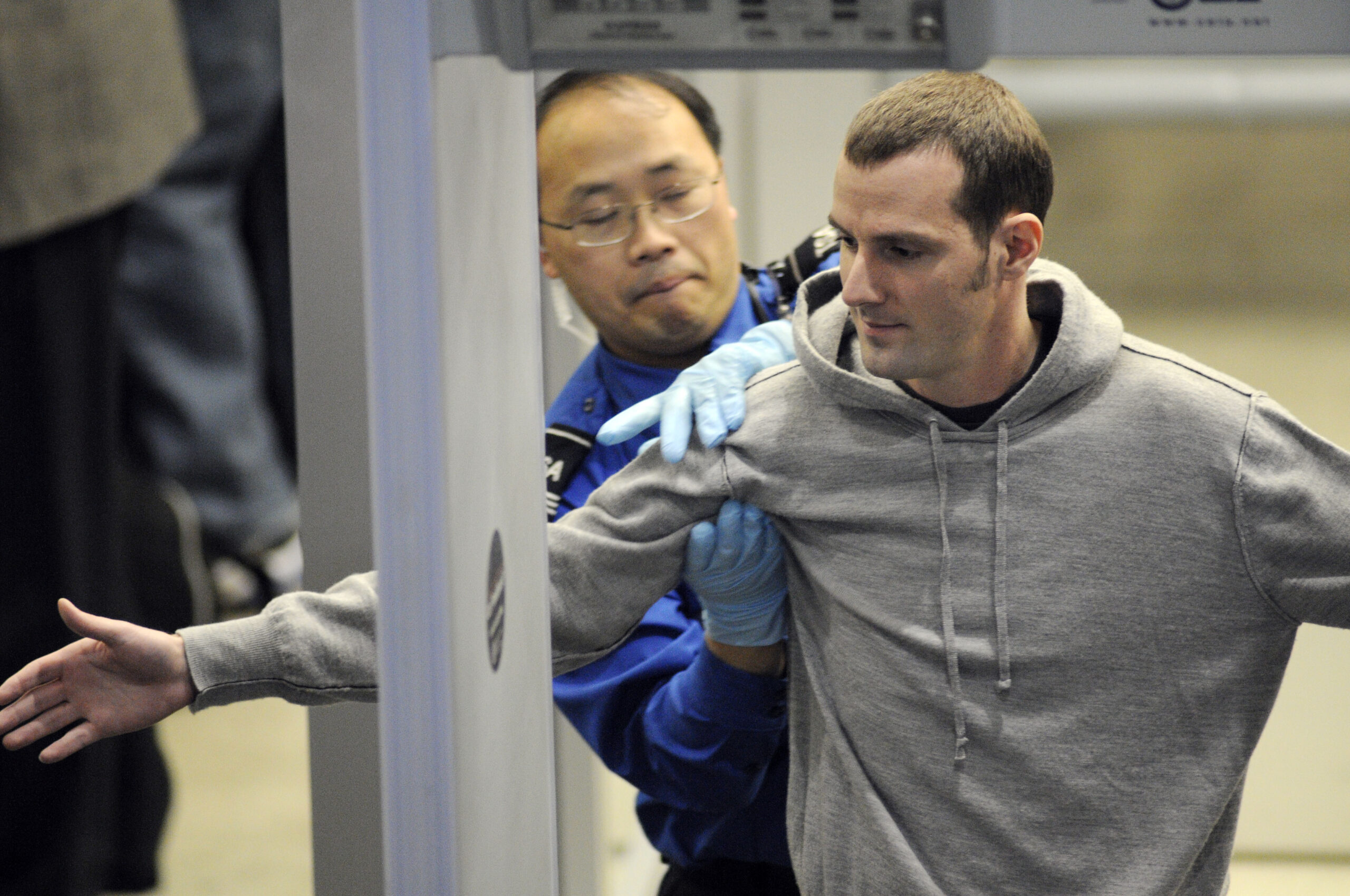Transportation Security Administration (TSA) officer pats down a traveler as he works his way through security at the Minneapolis-St. Paul International Airport in Bloomington, Minn., Wednesday, Nov. 24, 2010.  (AP Photo/Craig Lassig)