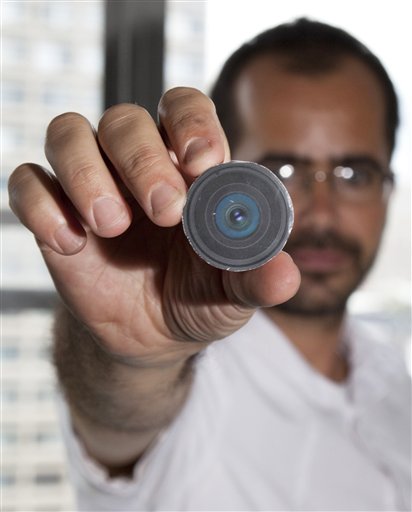 This Aug. 24, 2010 photo provided by New York University arts professor Wafaa Bilal, shows Bilal holding the prototype of a digital camera that he had implanted in the back of his head, in New York.  Bilal, a visual artist widely recognized for his interactive and performance pieces, has undergone surgery to implant a tiny camera in the back of his head for an artwork commissioned by a new museum in Doha, Qatar. Titled "The 3rd I," it is one of 23 contemporary works commissioned for the opening of Mathaf: Arab Museum of Modern Art on Dec. 30, 2010. (AP Photo/Wafaa Bila, Bard Farwell) NO SALES (AP)