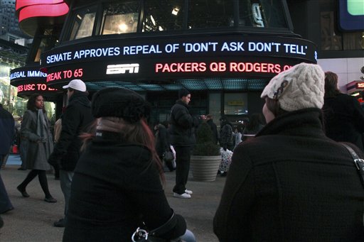 Cassandra Melnikow, foreground left, and her sister Victoria Melnikow,  right, sit in New York's Times Square as news of the Senate approving the repeal of "Don't Ask Don't Tell" is displayed outside ABC Television's Times Square studios Saturday Dec. 18, 2010. (AP Photo/Tina Fineberg) (AP)