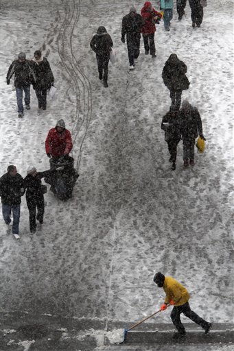 A maintenance worker clears snow from the sidewalk during a snowstorm on Broadway in New York's Times Square,  Sunday, Dec. 26, 2010 in New York.  (AP Photo/Mary Altaffer) (AP)