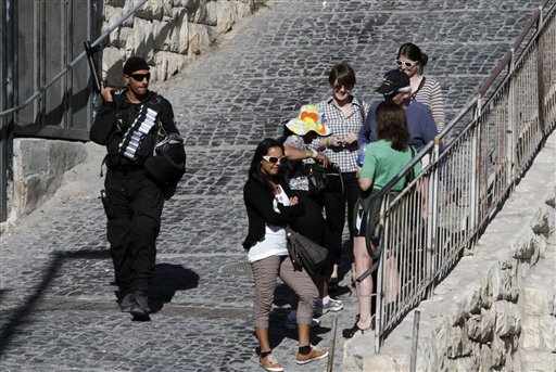An Israeli riot policeman walks next to a group of tourists in the east Jerusalem neighborhood of Silwan, Sunday, Dec. 26, 2010. (AP Photo/Dimitri Messinis) (AP)