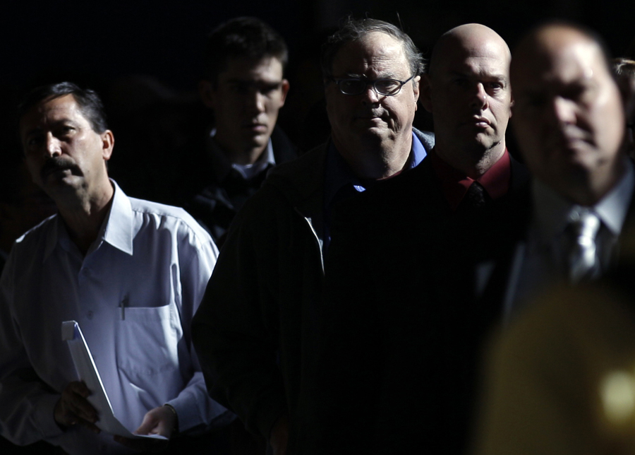In this Nov. 30, 2010 photo, Mark Chavez, second from right, waits in a line to register at a career fair in San Diego. More Americans signed up for unemployment benefits last week, but the broader trend in layoffs still points to a slowly healing jobs market. (AP Photo/Gregory Bull) (Gregory Bull)