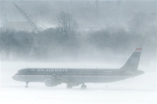 A U.S. Airways jet is seen amidst snow blown by gust of wind at the Philadelphia International Airport  in Philadelphia, Monday, Dec. 27, 2010. A powerful East Coast blizzard menaced would-be travelers by air, rail and highway Monday, leaving thousands without a way to get home after the holidays and shutting down major airports and rail lines for a second day. (AP Photo/Matt Rourke) (Matt Rourke)