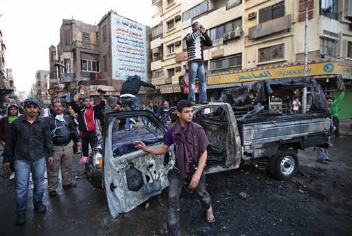 Egyptian anti-government activists, some standing on a burned police car challenge riot police officers, not seen, during clashes in Cairo, Egypt, Friday Jan. 28, 2011. Tens of thousands of anti-government protesters poured into the streets of Egypt Friday, stoning and confronting police who fired back with rubber bullets and tear gas in the most violent and chaotic scenes yet in the challenge to President Hosni Mubarak's 30-year rule. (AP Photo/Lefteris Pitarakis) (AP)