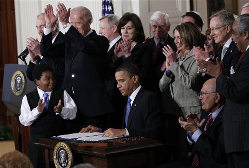 President Obama is applauded after signing the health care bill. (AP Photo/Charles Dharapak, File) (AP)