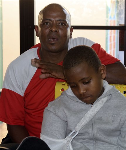 In this photo taken Wednesday, Jan. 5, 2011, earthquake survivors Prevener Julien, left, and his son Belix Julien, eight-years-old, recall the day the earthquake hit Haiti last January 12, 2010, as he talks to a reporter in Miami. (AP Photo/Alan Diaz) (AP)