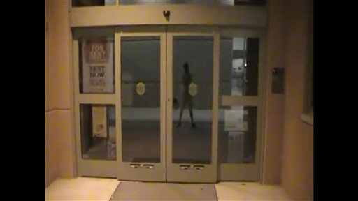 In this image taken from a YouTube video posted by Jared Lee Loughner and released by Pima Community College to the Associated Press , a campus books  station is shown at Pima Community College, with the reflection of Loughner  in Tucson, Ariz. The video shot by the suspected gunman in the attack on Rep. Gabrielle Giffords and others showed the former community college student touring campus at night and at times rambling about free speech and the Constitution.  (AP Photo/Pima Community College) (AP)