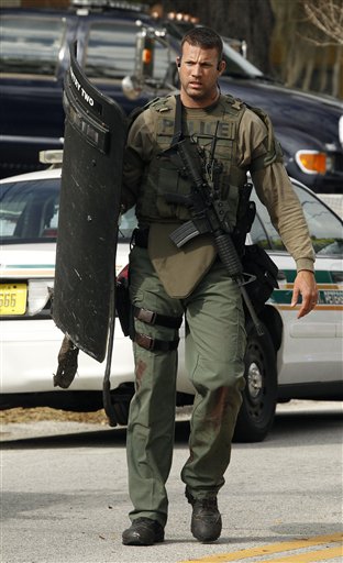 A heavily armed SWAT team member walks away from the scene where three officers were shot Monday, Jan. 24, 2011 in south St. Petersburg, Fla.  Police say a gunman suspected of killing two Florida police officers and wounding a U.S. marshal during a shootout has been found dead. St. Petersburg Police spokesman Michael Puetz says the suspect was found dead when officers went into the home Monday afternoon, about six hours after the shootout. Puetz said officers originally went to the home to arrest 39-year-old Hydra Lacy Jr.  (AP Photo/Chris O'Meara) (AP)