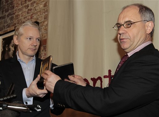 Former Swiss banker by Rudolf Elmer hands two CD cases full of files to WikiLeaks founder Julian Assange, left, following a news conference at the Frontline Club in London, Monday Jan. 17, 2011. Elmer blew the whistle on the conduct of Julius Baer Bank in the Cayman Islands for which he is set to stand trial in Zurich, Switzerland, on Jan. 19 for breaching Swiss bank secrecy laws. Accompanied by his lawyer Jack Blum, he will reveal more details of alleged abuses in the world of offshore financial centres. As he did back in 2007 he will pass the said documents and information to Wikileaks.(AP Photo/Lefteris Pitarakis) (AP)