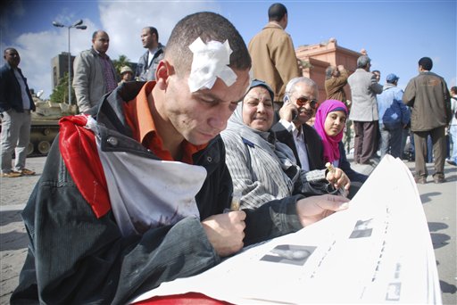 A wounded man reads a newspaper in Cairo, Egypt, Monday Jan. 31, 201. A coalition of opposition groups called for a million people to take to Cairo's streets Tuesday to ratchet up pressure for President Hosni Mubarak to leave.  (AP Photo/Mohammed Abou Zaid) (AP)