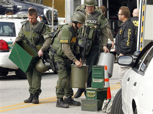Swat team members stack their gear after the suspect in the shooting of three law enforcement officers was found dead Monday, Jan. 24, 2011 in south St. Petersburg, Fla.  Police say a gunman suspected of killing two Florida police officers and wounding a U.S. marshal during a shootout has been found dead. St. Petersburg Police spokesman Michael Puetz says the suspect was found dead when officers went into the home Monday afternoon, about six hours after the shootout. Puetz said officers originally went to the home to arrest 39-year-old Hydra Lacy Jr.  (AP Photo/Chris O'Meara) (AP)