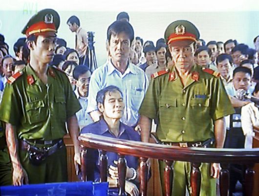 In this 2007 file photo, Catholic priest Nguyen Van Ly, lower center, is seen in a courtroom in Vietnam's central province of Thua Thien Hue.