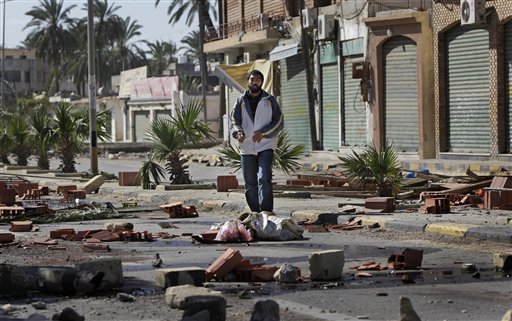 A man walks through roadblocks made by residents in the Tajoura district of eastern Tripoli, Libya, Saturday, Feb. 26, 2011. Residents there have blocked many streets with roadblocks after protesters demanding Moammar Gadhafi's ouster came under a hail of bullets Friday when pro-regime militiamen opened fire to stop the first significant anti-government marches in days in the Libyan capital.  (AP Photo/Ben Curtis) (AP)