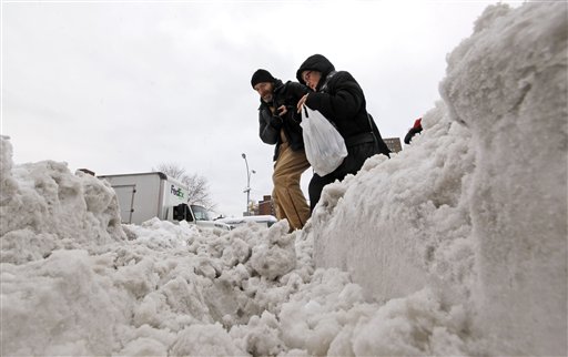 A man helps an elderly woman cross a snow-covered street on the Lower East Side of Manhattan, Thursday, Jan. 27, 2011, in New York. (AP Photo/Mary Altaffer) (AP)