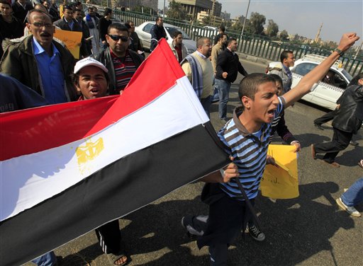Anti-government protesters wave an Egyptian flag during a march in Cairo, Egypt, Friday, Feb. 11, 2011. Egypt's powerful military backed President Hosni Mubarak's plan to stay in office until September elections, but massive crowds outraged by his refusal to step down packed squares in Egypt's two biggest cities Cairo and Alexandria on Friday. (AP Photo/Amr Nabil) (AP)