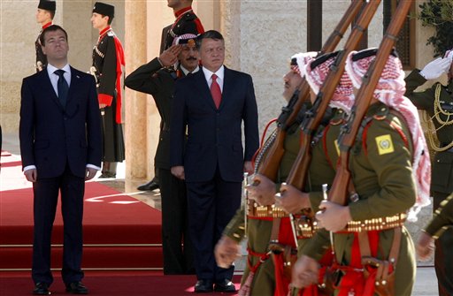 King Abdullah II of Jordan, center, and Russian President Dmitry Medvedev, left, review the Bedouin guards of honor during an official welcoming ceremony prior their talks, in Amman, Jordan, Wednesday, Jan. 19, 2011. (AP Photo/Nader Daoud) (AP)
