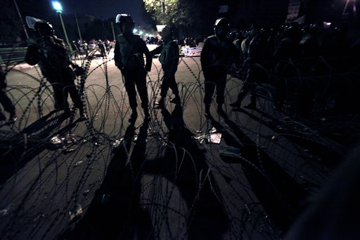 Egyptian army soldiers stand alert in front of barbed wire at the entrance of  Tahrir Square in downtown Cairo, Egypt Thursday, Feb. 10, 2011. Egypt's military announced on national television it had stepped in to secure the country and promised protesters calling for President Hosni Mubarak's ouster that all their demands would soon be met. Tens of thousands of protesters packed in central Tahrir broke into chants of 'We're almost there, we're almost there' and waved V-for-victory signs as thousands more flowed in to join them well after nightfall. (AP Photo/Amr Nabil) (AP)