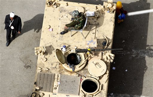 A wounded anti-government protestor walks past a military tank in Tahrir Square, Cairo, Egypt, Friday, Feb. 4, 2011. The Egyptian military guarded thousands of protesters pouring into Cairo's main square on Friday in an attempt to drive out President Hosni Mubarak after a week and half of pro-democracy demonstrations. (AP Photo/Tara Todras-Whitehill) (AP)