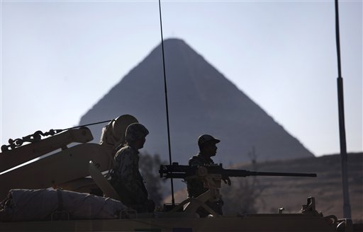 Egyptian Army soldiers are seen on top of an APC vehicle near the pyramids, in Giza, Egypt, Monday, Jan. 31, 2011. The pyramids are closed to tourists.  A coalition of opposition groups called for a million people to take to Cairo's streets Tuesday to demand the removal of President Hosni Mubarak (AP Photo/Emilio Morenatti) (AP)