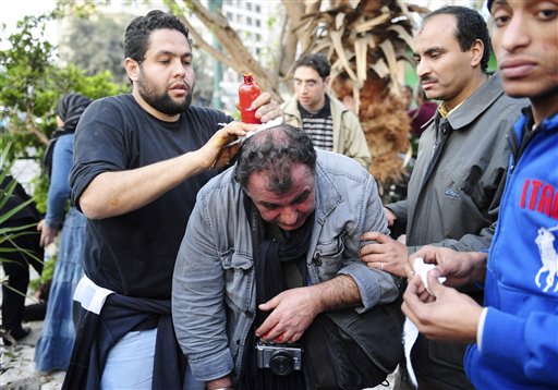 French photojournalist from SIPA Press agency Alfred Yaghobzadeh is being treated by anti-government protestors after being wounded during clashes between pro-government supporters and anti-government protestors, in Cairo's central Tahrir Square, Wednesday Feb. 2, 2011 in Cairo, Egypt.  The Egyptian military has started Thursday Feb.3, 2011 rounding up journalists, possibly for their own protection, after they came under attack from supporters of President Hosni Mubarak who have been attacking anti-government protesters. (AP Photo) (AP)