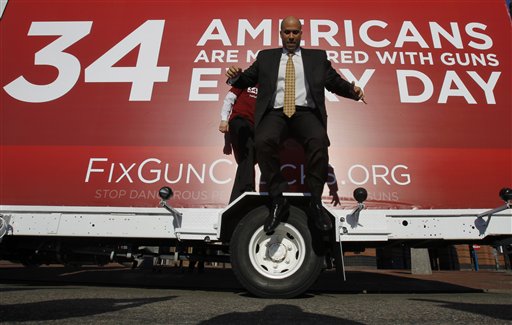 Newark Mayor Cory Booker leaps from the wheel cover of a mobile billboard after taking photos on it during part of the FixGunChecks.org Truck tour stop, Wednesday, Feb. 16, 2011, in Newark, N.J. The truck will be driven across the nation as part of the Mayors Against Illegal Guns which was launched by New York City Mayor Michael R. Bloomberg Wednesday. Its purpose will be to draw public attention to the deadly problems in the nations gun background check system. (AP Photo/Julio Cortez) (AP)
