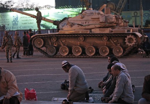 Anti-government protesters offer their evening prayers, in front of an Egyptian army tank securing the area, during a protest in Cairo's Tahrir Square, Egypt, Monday, Jan. 31, 2011. A coalition of opposition groups called for a million people to take to Cairo's streets Tuesday to demand the removal of Egyptian President Hosni Mubarak. (AP Photo/Lefteris Pitarakis) (AP)