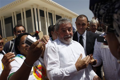 Supporters surround former Brazilian President Luiz Inacio Lula da Silva, center, as he arrives for a World Social Forum event at Place du Souvenir in Dakar, Senegal, Monday, Feb. 7, 2011. The World Social Forum kicked off in this corner of west Africa on Sunday, its mantra of social change "another world is possible" proving especially resonant as anti-government uprisings continue to rock Egypt in the northern part of the continent. (AP Photo/Rebecca Blackwell) (AP)