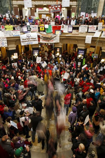 Protesters to the governor's bill to eliminate collective bargaining rights for many state workers march through the center of the rotunda at the state Capitol in Madison, Wis., Friday, Feb. 25, 2011.  Protests are in their 11th day at the Capitol. (AP Photo/Andy Manis) (AP)