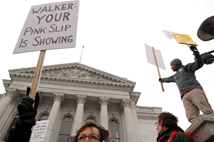 Protesters listen to a rally as sleet falls outside the state Capitol Monday, Feb. 21, 2011, in Madison, Wis. Opponents to Governor Scott Walker's bill to eliminate collective bargaining rights for many state workers are taking part in their seventh day of protesting.  (AP Photo/Jeffrey Phelps) (Jeffrey Phelps)