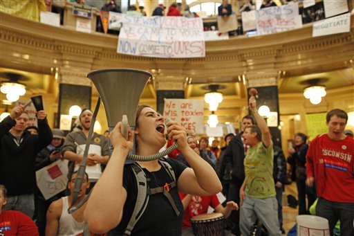 Protesters bang drums and shout slogans inside the state Capitol Monday, Feb. 21, 2011, in Madison, Wis. Opponents to Gov. Scott Walker's bill to eliminate collective bargaining rights for many state workers are taking part in their seventh day of protesting.  (AP Photo/Jeffrey Phelps) (AP)