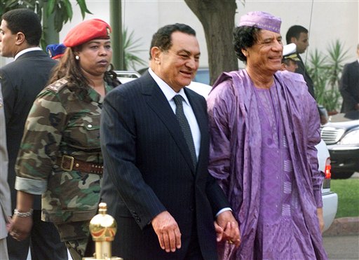 FILE.- This July 21, 2002  file photo shows Egyptian President Hosni Mubarak, center, welcoming Libyan leader Moammar Gadhafi, right, who is guarded by a female bodyguard, left, upon his arrival at the Presidential Palace in Cairo. Hundreds of Libyans calling for the government's ouster took to the streets early Wednesday in the country's second-largest city as Egypt-inspired unrest spread to the country long ruled by Moammar Gadhafi. (AP Photo/Amr Nabil) (AP)