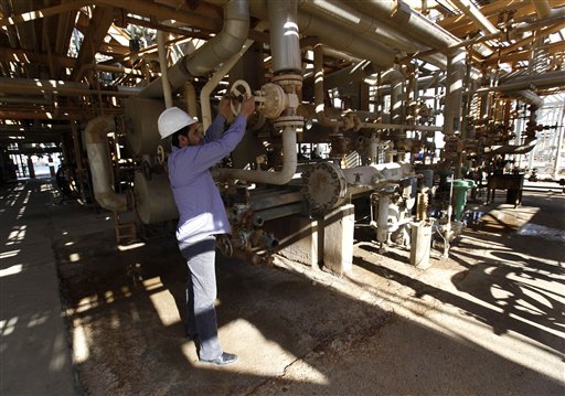 A Libyan oil worker, works at a refinery inside the Brega oil complex, in Brega east of Libya, on Saturday Feb. 26, 2011. Production at Brega has dropped by almost 90 percent amid the country's crisis because many employees have fled and few ships are coming to offload the product. (AP Photo/Hussein Malla) (AP)