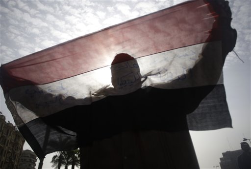 An anti-government demonstrator holds an Egyptian flag in Tahrir Square, Cairo, Egypt, Friday, Feb. 4, 2011. The Egyptian military guarded thousands of protesters pouring into Cairo's main square on Friday in an attempt to drive out President Hosni Mubarak after a week and half of pro-democracy demonstrations. (AP Photo/Sebastian Scheiner) (AP)