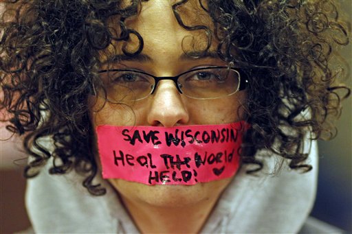Kathryn Schulze wears a message written on tape over her mouth inside the state Capitol Monday, Feb. 21, 2011, in Madison, Wis. Opponents to Governor Scott Walker's bill to eliminate collective bargaining rights for many state workers are taking part in their seventh day of protesting. (AP Photo/Jeffrey Phelps) (AP)
