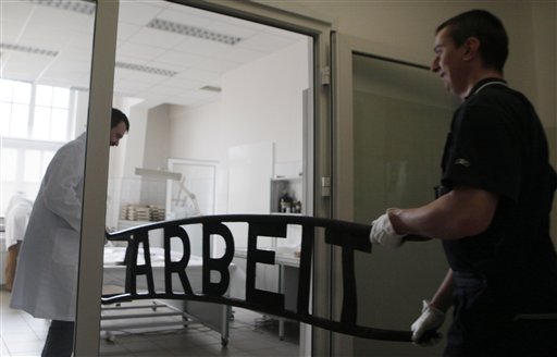 This image taken Jan. 28, 2011 shows conservation worker  Andrzej Jastrzebowski, left, carrying  the gate sign of the death camp in the modern laboratory of the Nazi death camp Auschwitz in Oswiecim, Poland. Officials  launched a global campaign to raise euro120 million ($165 million) to create a "perpetual fund" whose interest can be drawn on indefinitely to repair barracks, watchtowers, crematoria and other structures at the Auschwitz-Birkenau state museum and memorial in southern Poland. (AP Photo/Czarek Sokolowski) (AP)
