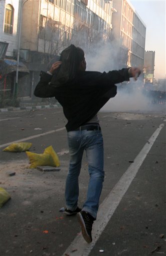 This photo, taken by an individual not employed by the Associated Press and obtained by the AP outside Iran shows an Iranian protestor throwing stone at ant-riot police officers, during an anti-government protest in Tehran, Iran, Monday, Feb. 14, 2011. Eyewitnesses report that sporadic clashes have erupted in central Tehran's Enghelab or Revolution square between security forces and opposition protesters. The demonstrators were chanting "death to the dictator," referring to the country's hardline president that the opposition believes was reelected through fraud in 2009. (AP Photo) EDITORS NOTE AS A RESULT OF AN OFFICIAL IRANIAN GOVERNMENT BAN ON FOREIGN MEDIA COVERING SOME EVENTS IN IRAN, THE AP WAS PREVENTED FROM INDEPENDENT ACCESS TO THIS EVENT (AP)