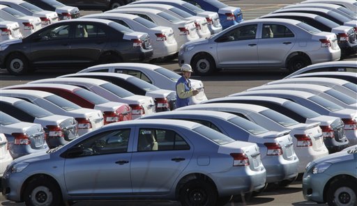 A worker checks Yaris compact sedans, set for export to North America, at a plant of Toyota Motor Co.'s group company Central Motor Co. in Ohira in Miyagi Prefecture, northern Japan, Wednesday, Feb. 16, 2011. Toyota celebrated the opening of the auto plant in a forsaken rural area of Japan, which promises to grow into a new production point for the world's largest automaker. (AP Photo/Koji Sasahara) (AP)