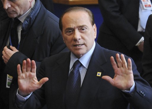 Italy's Prime Minister Silvio Berlusconi motions to the media as he leaves an EU summit in Brussels, Friday, Feb. 4, 2011. EU leaders meet for a one-day summit on Friday, with energy, the eurozone debt crisis and unrest in Egypt set to dominate the agenda. (AP Photo/Thierry Charlier) (AP)