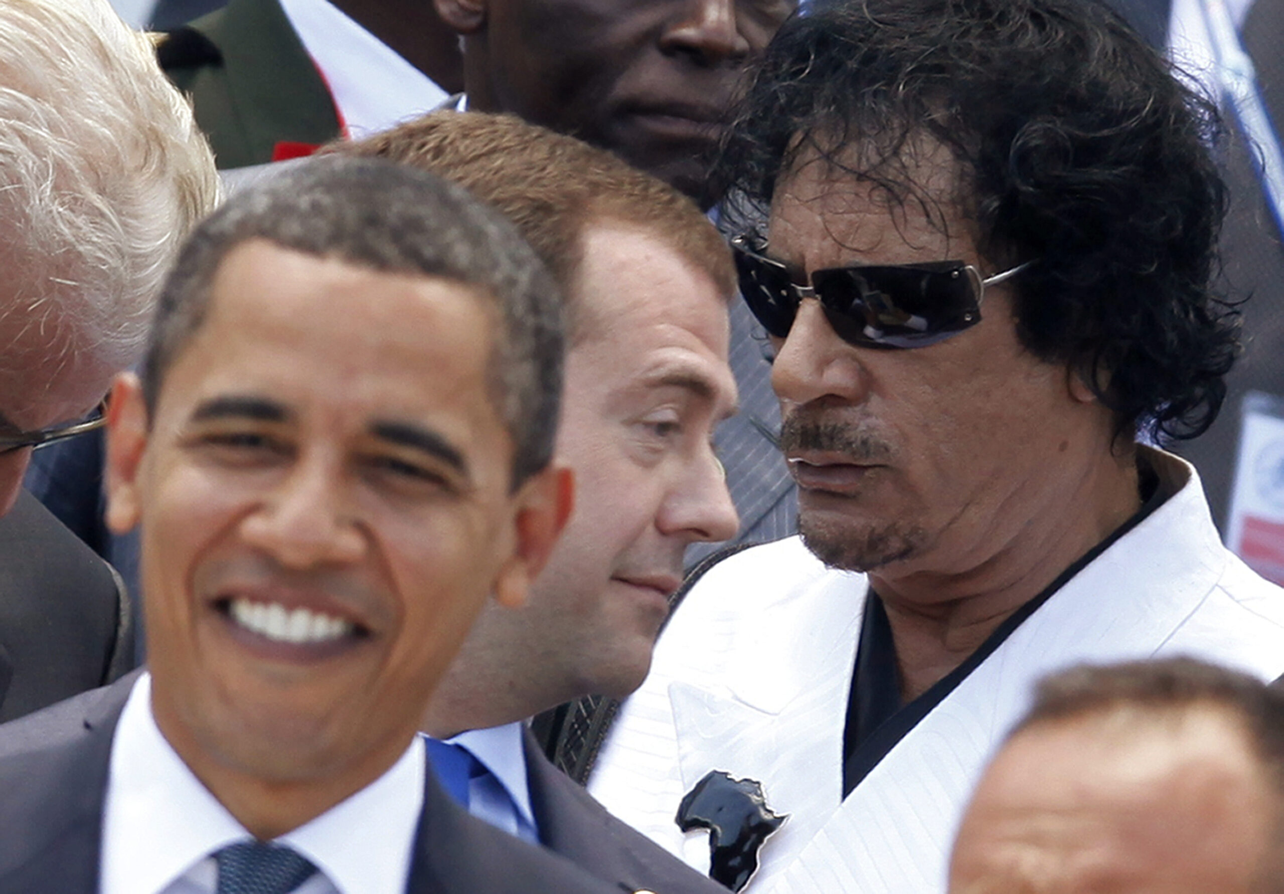 Libyan leader Moammar Gadhafi, right, Russian President Dmitry Medvedev, center, and President Barack Obama get in position for a group photo at the G8 Summit in L'Aquila, Italy, Friday, July 10, 2009. (AP Photo/Charles Dharapak) (AP)