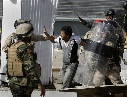 Iraqi police arrest a protester during a demonstration in Baghdad, Iraq, Friday, Feb. 25, 2011. Thousands marched on government buildings and clashed with security forces in cities across Iraq on Friday, in the largest and most violent anti-government protests here since political unrest began spreading in the Arab world several weeks ago. (AP Photo/Hadi Mizban) (AP)
