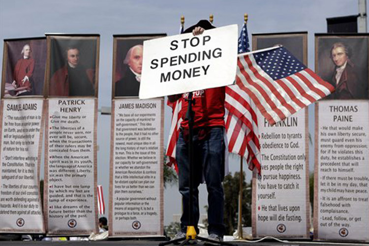 Michael Fell, of Culver City, Calif., holds up a sign reading "STOP SPENDING MONEY" as he speaks at a tea party rally in Irvine, Calif., Thursday, April 15, 2010. (AP Photo/Jae C. Hong) (Jae C. Hong)