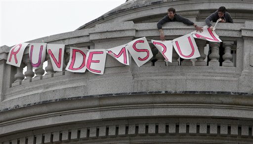 Two protestors put up a sign at the State Capitol in Madison, Wis., Thursday, Feb. 17, 2011, that reads "Run Dems Run" in support of 14 state Senators that have left the state in opposition to Wisconsin Gov. Scott Walker's bill to eliminate collective bargaining rights for many state workers. (AP Photo/Andy Manis) (AP)
