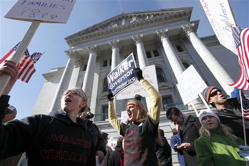 Scott Walker supporters, from left,  Elise Kurz , Aimee Hilber, Haddie Carlson and her father, Brucestand, demonstrate outside the Wisconsin State Capitol during a rally on  Saturday, Feb.  19, 2011 in Madison.   A few dozen police officers stood between supporters of GOP Gov. Scott Walker on the muddy east lawn of the Capitol and the much larger group of pro-labor demonstrators who surrounded them. The protest was peaceful as both sides exchanged chants of Pass the bill! Pass the bill! and Kill the bill! Kill the bill!  (AP Photo/Wisconsin State Journal, John Hart) (AP)